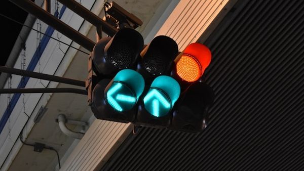 Zwei Ampeln, ein grüner Pfeil zeigt nach links, einer nach oben, zusätzlich leuchtet eine Ampel rot