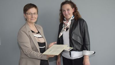 Zwei Frauen halten ein historisches Dokument in der Hand