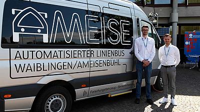 Zwei Mitarbeiter des Projekts Ameise stehen neben dem Kleinbus.