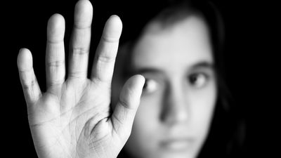 Mädchen signalisiert STOP mit flacher Hand; Kampagne gegen Gewalt, Gender und sexuelle Diskriminierung