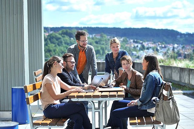 Studierende sitzen auf der Terrasse am Campus Flandernstraße