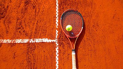 Tennisschläger und Tennisball am Court als Symbol für Tennis
