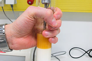 Student holds filled test tube in his hand 