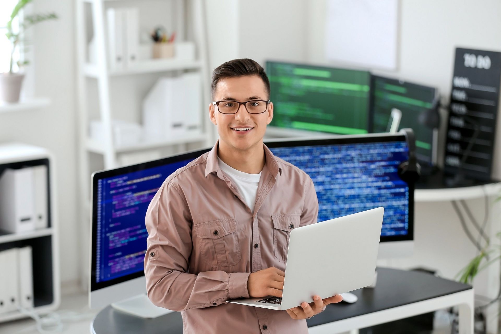 Mann mit Laptop in der Hand in einem Büro