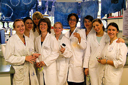 Eine Gruppe von Studentinnen in Laborkitteln nach dem Färben mit Indigo