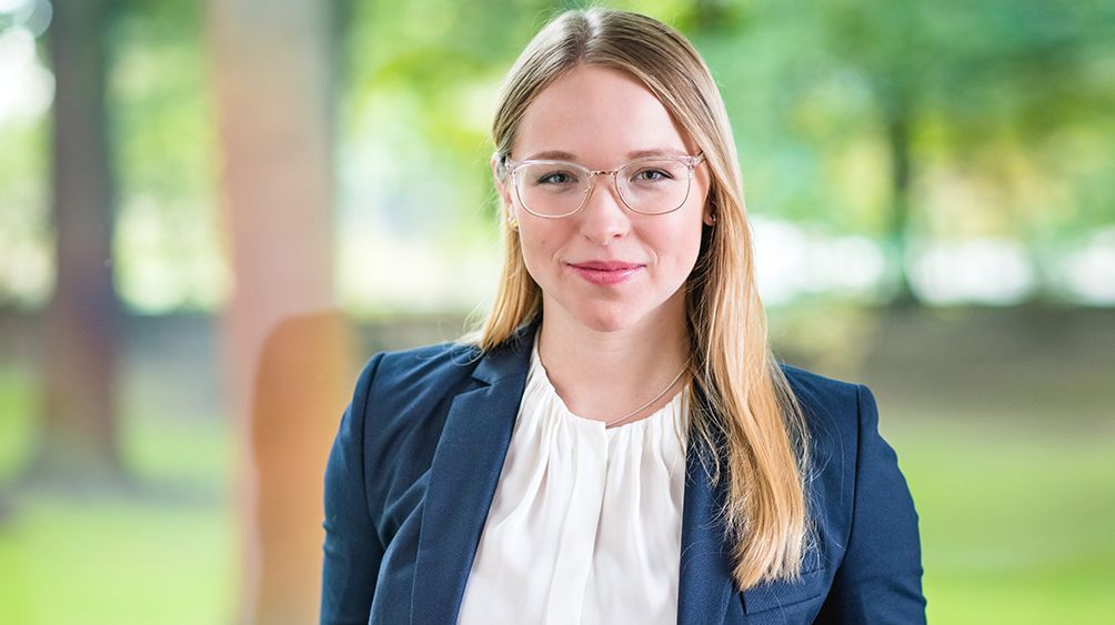 Eine junge blonde Frau mit Brille.