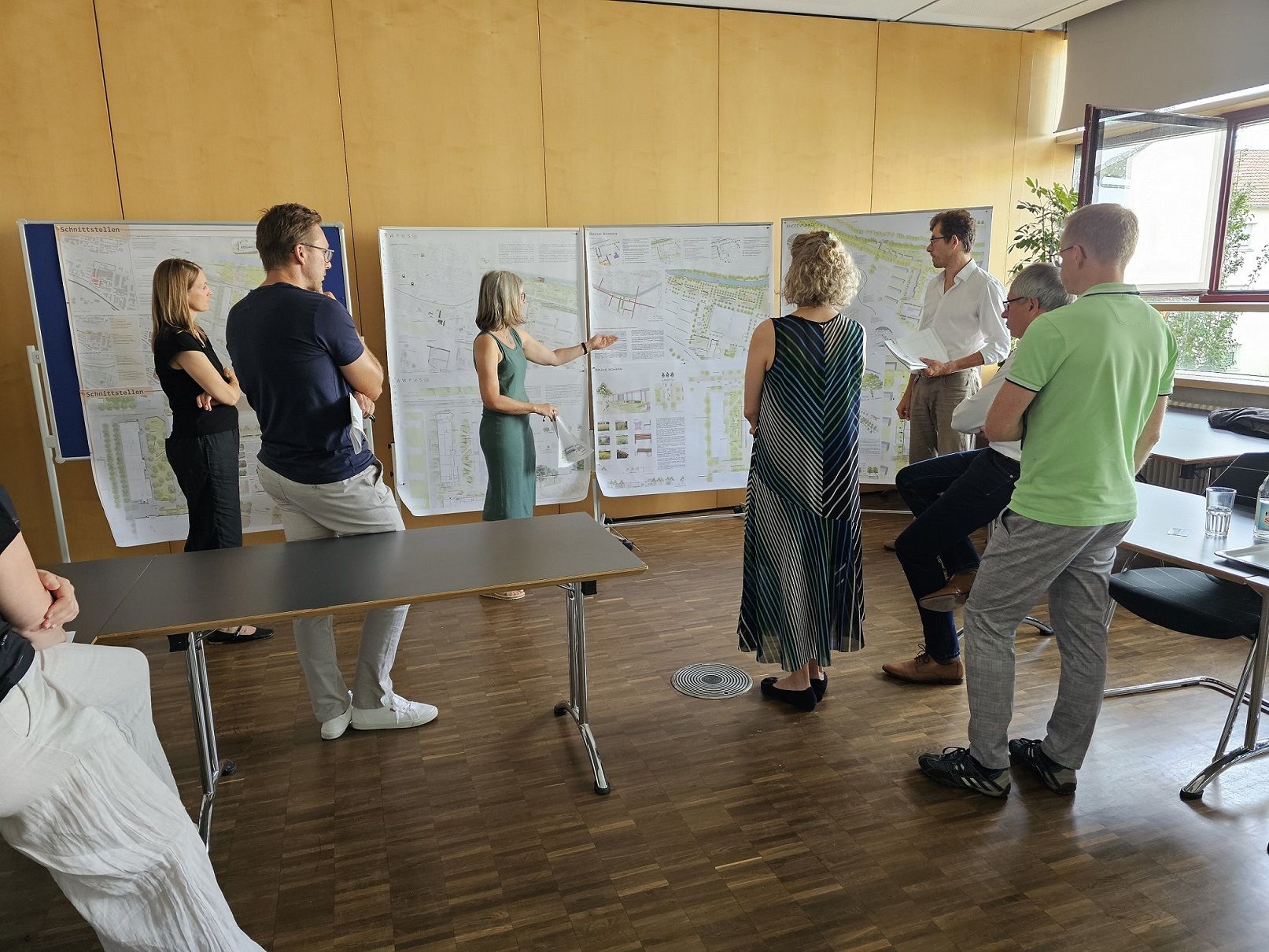 Mehrere Personen schauen sich Pläne für die Neugestaltung des Campus Göppingen an